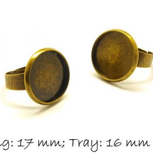 Op de afbeelding: Twee ringen van goudkleurig metaal met een ronde tray voor het instellen van een cabochon. De ring aan de linkerkant heeft een ring met een diameter van 17 mm en een tray met een diameter van 16 mm. De ring aan de rechterkant heeft een tray met een diameter van 16 mm.