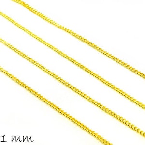 Può includere: Tre fili di catena d'oro, ciascuno misura 2 x 1 mm. Le catene sono disposte in linee parallele su uno sfondo bianco.