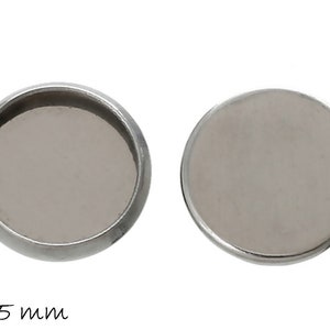 Könnte beinhalten: Zwei runde, silberfarbene, leere Cabochonfassungen aus Metall mit einem Durchmesser von 25 mm.