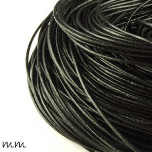 May include: A close-up of a spool of black leather cord, approximately 1 mm in diameter.