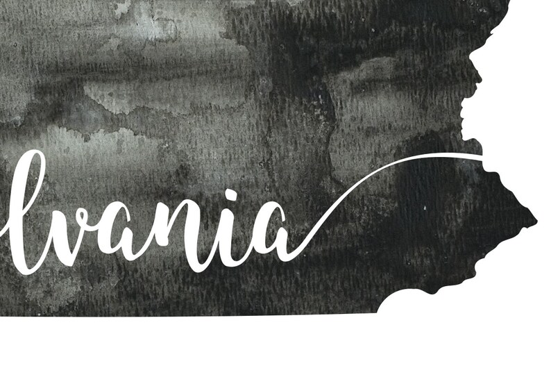 May include: A black and white watercolor illustration of the state of Pennsylvania with the word "Pennsylvania" written in white cursive script.