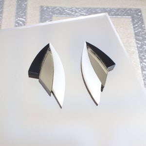 May include: A pair of geometric earrings in black and white with a mirrored finish.