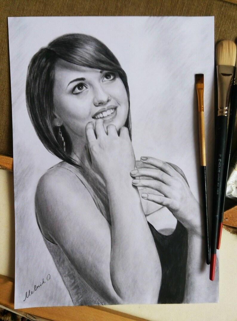 Puede incluir: Un dibujo a l&aacute;piz en blanco y negro de una mujer con el pelo corto y casta&ntilde;o, sonriendo y mirando hacia arriba. La mujer lleva una camiseta sin mangas y tiene las manos cerca de la cara.