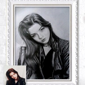 Puede incluir: Un dibujo a l&aacute;piz en blanco y negro enmarcado de una persona con el pelo largo que lleva una chaqueta de cuero negra. El dibujo est&aacute; en un marco blanco con un borde decorativo.