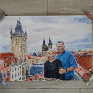 May include: A watercolor painting of a couple standing in front of a cityscape. The couple is dressed in casual clothing and is smiling. The cityscape is a mix of old and new buildings, with a large clock tower in the background.