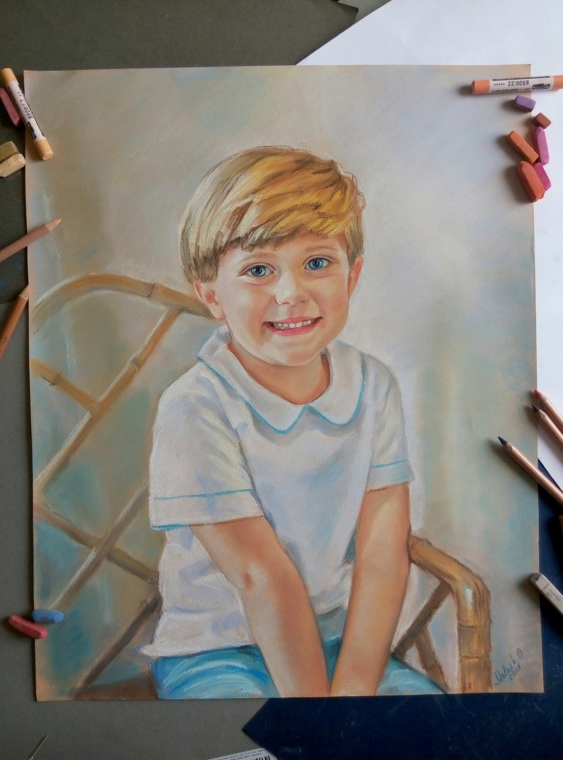 K&ouml;nnte beinhalten: Pastellzeichnung eines jungen Jungen mit blonden Haaren, blauen Augen und einem wei&szlig;en Hemd mit Kragen. Er sitzt auf einem Korbstuhl und l&auml;chelt.
