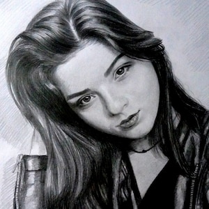 Puede incluir: Dibujo a l&aacute;piz en blanco y negro de una mujer con el pelo largo y oscuro. Lleva una chaqueta de cuero negra y mira directamente al espectador.