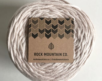 May include: A beige ball of cotton rope with a brown paper tag that says "ROCK MOUNTAIN CO. rockmountain.co | @rockmountainco"