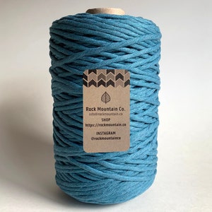 May include: A spool of teal blue cotton rope with a brown label that reads "Rock Mountain Co. info@rockmountain.co SHOP https://rockmountain.co INSTAGRAM @rockmountainco"