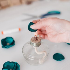 a person holding a tiny bottle with a cork in it