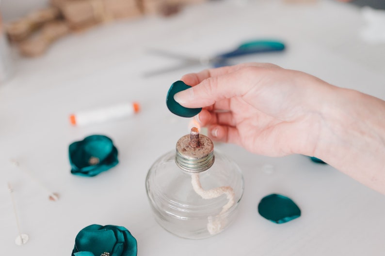 a person holding a tiny bottle with a cork in it