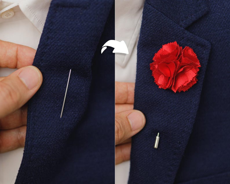 A close-up view of a person's lapel, showing a red flower pin and a needle used to attach it to the jacket.