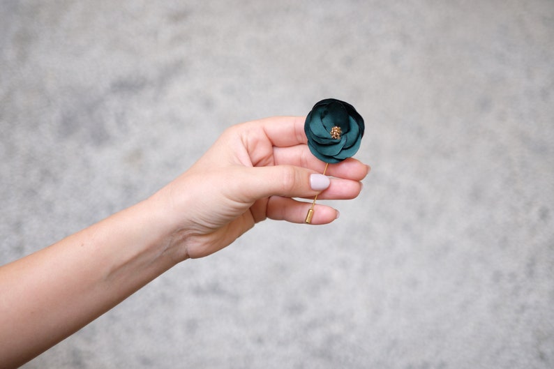 a person holding a green flower in their hand