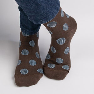 May include: A pair of brown socks with blue polka dots.