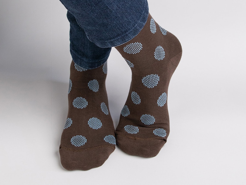 May include: A pair of brown socks with blue polka dots.