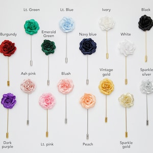 May include: Assortment of 18 silk flower lapel pins in various colors, including red, green, blue, ivory, black, burgundy, emerald green, navy blue, white, yellow, lilac purple, ash pink, blush, vintage gold, sparkle silver, dark purple, light pink, peach, and sparkle gold.