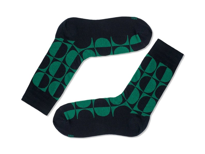 May include: A pair of dark blue socks with a geometric pattern of green half circles.