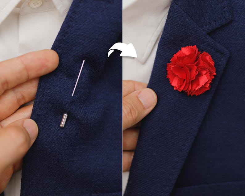 A close-up of a person's necktie with a red flower pin on the lapel, and a hand adjusting the pin.