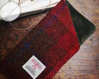 May include: A red and brown tweed eyeglass case with a green velvet lining. The case has a label that reads "Harris Tweed" and "Hand Woven Cloth."