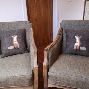 Può includere: Due poltrone in tweed marrone con telai in legno, ciascuna con un cuscino di volpe marrone e bianco.