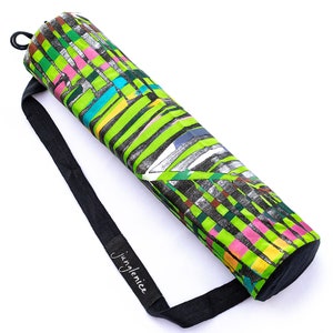 May include: A green, black and pink yoga mat carrier with a black adjustable strap and the word "JingleNice" printed on the strap.