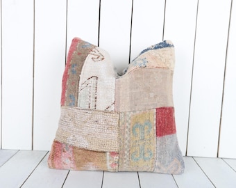 Puede incluir: Una funda de cojín de patchwork con una variedad de colores y patrones, incluyendo beige, marrón, rojo y azul.