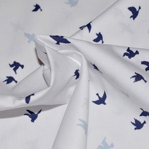 May include: White fabric with a repeating pattern of dark blue flying birds.