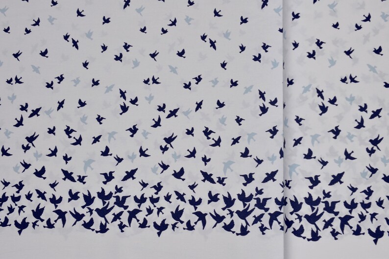 May include: White fabric with a repeating pattern of dark blue birds flying in different directions. The birds are scattered across the fabric, creating a dynamic and lively design.