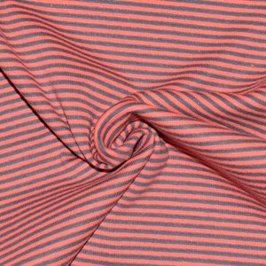 May include: Red and black striped fabric with a soft, textured feel. The fabric is folded and draped, showing the stripes and texture.