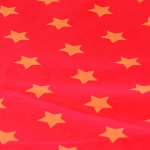 Può includere: Tessuto rosso con un motivo ripetitivo di stelle gialle.