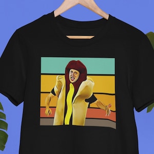 May include: Black t-shirt with a retro-style graphic of a person dressed as a hot dog. The graphic has a yellow mustard, red ketchup, and white bun design.