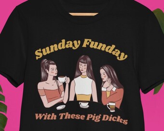 May include: Black t-shirt with a graphic of three women drinking coffee and the text "Sunday Funday with These Pig Dicks".