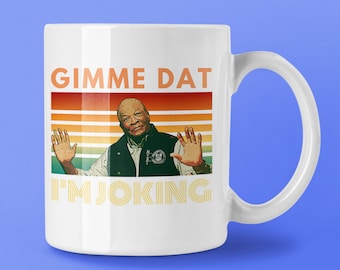 May include: White ceramic mug with a retro-style design featuring a man with a mustache and the text "Gimme Dat I'm Joking".
