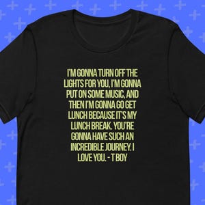May include: Black t-shirt with the text "I'M GONNA TURN OFF THE LIGHTS FOR YOU...I LOVE YOU. - T BOY" in a light yellow color. The shirt has short sleeves and a crew neck.