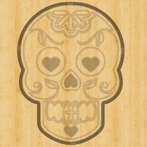 Op de afbeelding: Een bruine houten uitsnijding van een suiker schedel met ingewikkelde details, waaronder harten voor de ogen en een bloemenontwerp op de bovenkant van het hoofd.