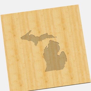 Könnte beinhalten: Ein Holzausschnitt des Bundesstaates Michigan. Der Ausschnitt befindet sich auf einem hellbraunen Holzgrund.
