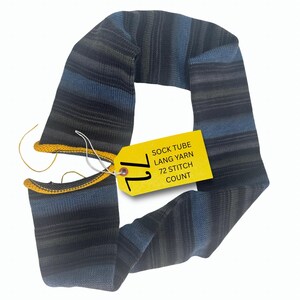 May include: A knitted sock tube in shades of blue, gray, and black with horizontal stripes. The tube has a yellow tag attached with the text "SOCK TUBE LANG YARN 72 STITCH COUNT". The edges are finished with yellow yarn.