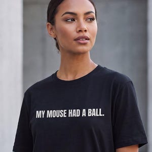 May include: A black short-sleeved t-shirt featuring the white text 'MY MOUSE HAD A BALL.' printed across the chest. The shirt has a crew neckline and a standard fit. The text 'Retro Tech' and 'The Tee That Makes Plain Tees Forgettable.' appear above.