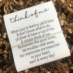 May include: A white card with a handwritten message that reads "think of me". The message continues with a poem about remembering good times and letting troubles melt away.
