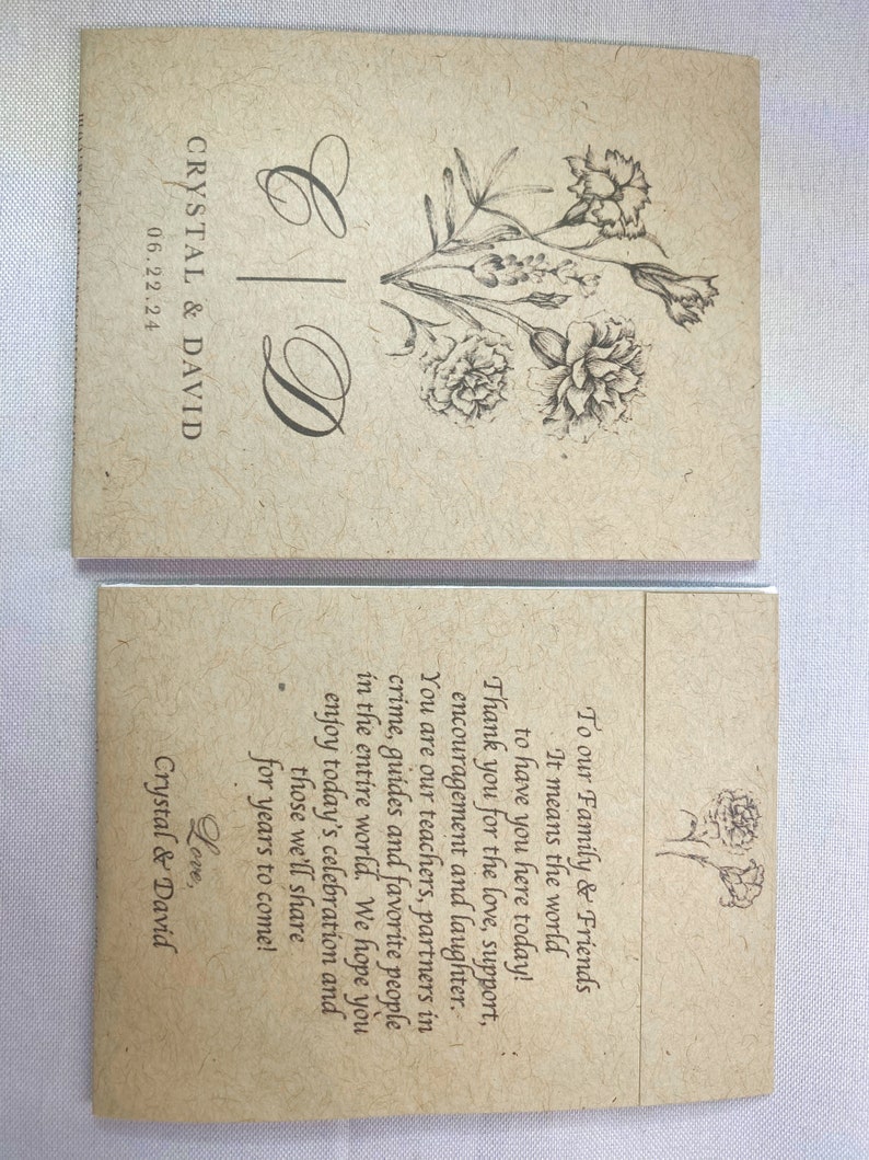 May include: A simple, rustic wedding announcement card with a floral design and the text "Crystal & David" and "06.22.24". The card is printed on brown paper with a textured surface.
