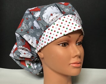 May include: A gray and white scrub hat with a red and white polka dot trim. The hat features a repeating pattern of Santa Claus faces.