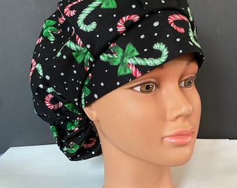 May include: Black scrub hat with a Christmas candy cane and bow print. The hat has white polka dots and is made of a soft, comfortable fabric.