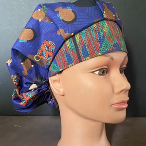 May include: A blue and black patterned surgical scrub hat with a colorful geometric design. The hat is made of a soft, comfortable fabric and is designed to be worn by medical professionals.