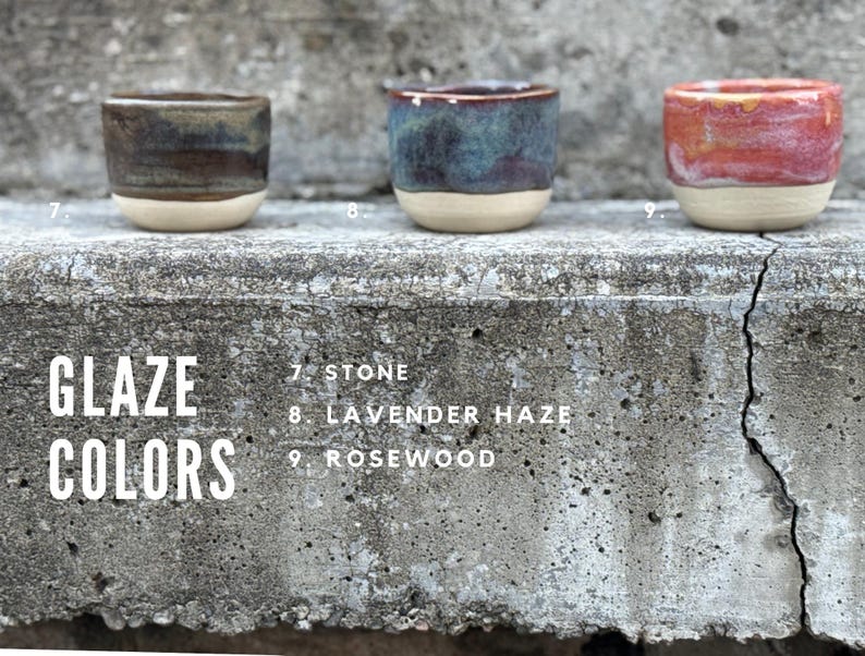K&ouml;nnte beinhalten: Drei kleine Keramikbecher mit unterschiedlichen Glasuren. Becher 7 ist Stone, eine Mischung aus Dunkelbraun und Grau. Becher 8 ist Lavender Haze mit Blau- und Violettt&ouml;nen. Becher 9 ist Rosewood mit leuchtenden Rot- und Oranget&ouml;nen. Alle haben einen cremefarbenen Boden.