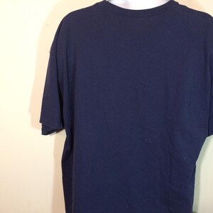 May include: A navy blue t-shirt with short sleeves.
