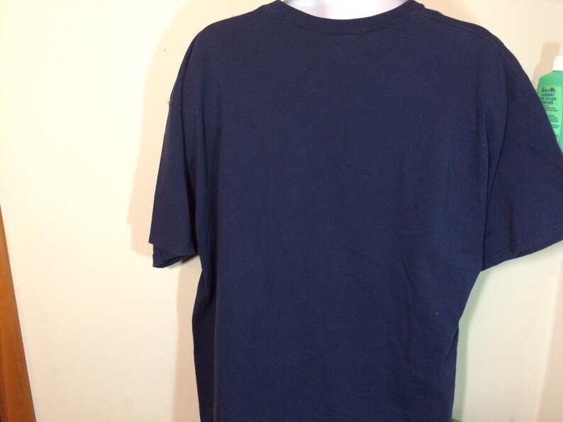 May include: A navy blue t-shirt with short sleeves.