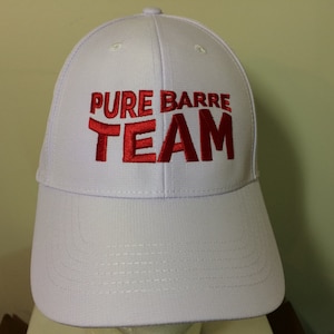 May include: White baseball cap with red embroidered text that reads "PURE BARRE TEAM"
