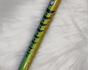 May include: A green and black pen with a fish design. The pen has a black tip and a silver clip.