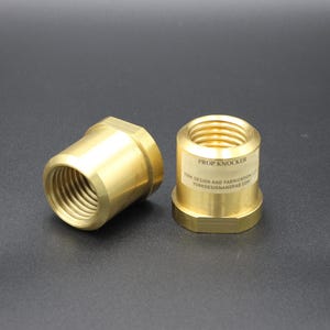 May include: Two brass-colored Prop Knocker fittings with internal threads. One is angled, the other has a label with text. The fittings are on a dark surface. The label reads "PROP KNOCKER" and "YORK DESIGN AND FABRICATION LTD".