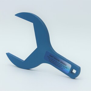 May include: A blue metal wrench with a square opening at the end of the handle. The wrench is labeled "Shaft Packing Wrench".